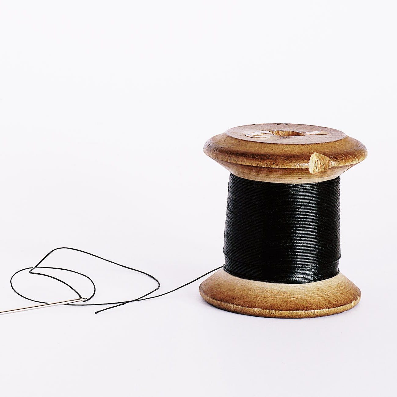 black thread on a wooden spool